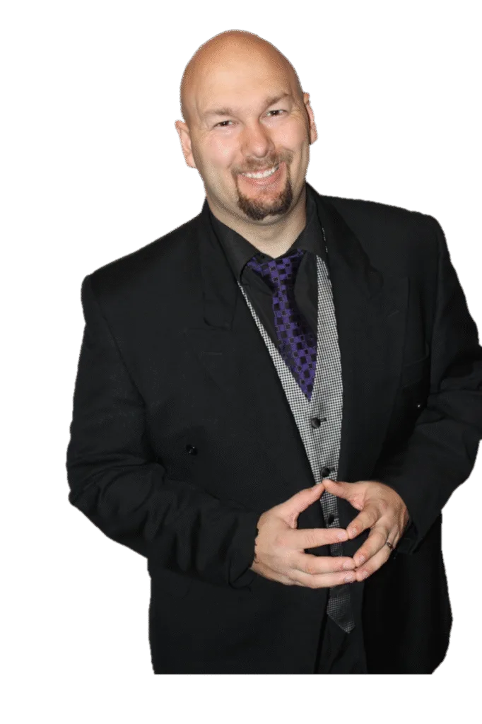 Jesse Lewis in formal black suit with hands together – professional comedy hypnotist headshot