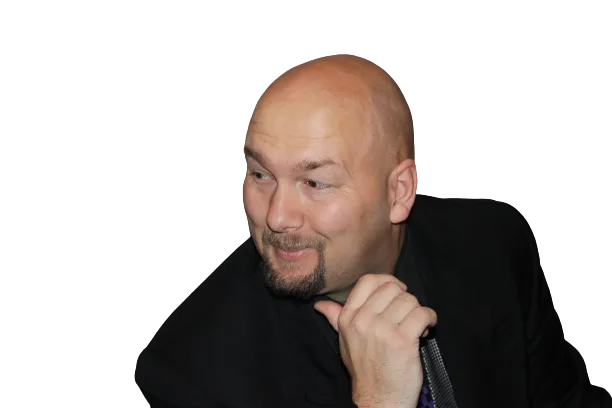 Jesse Lewis smiling in a suit while holding a microphone – comedy hypnotist promotional headshot