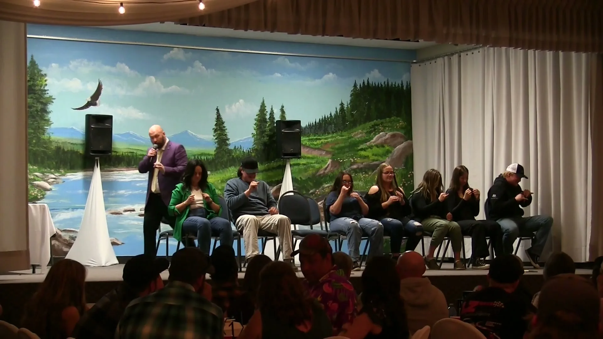 Comedy hypnosis volunteers reacting together onstage during a live show